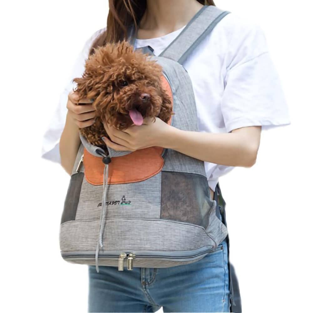 Brown curly dog in a comfortable small pet backpack with the adjustable opening, orange variant worn in the front of the model on white background. 