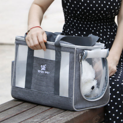 Small white dog peaking out of open zip opening to the Dodo Pet Tote Bag Carrier with handles being carried by human hand.